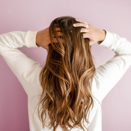 woman touching hair for hair restoration