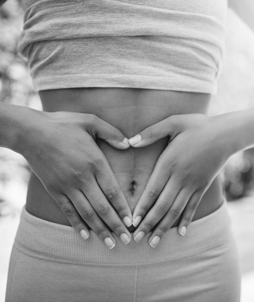 woman with hands on stomach for lipo suction in black and white